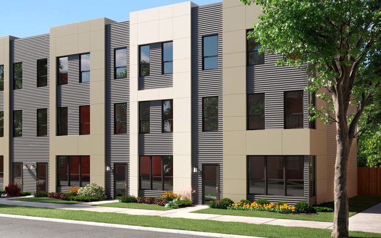 Modern Lexington townhomes along a landscaped street under a blue sky