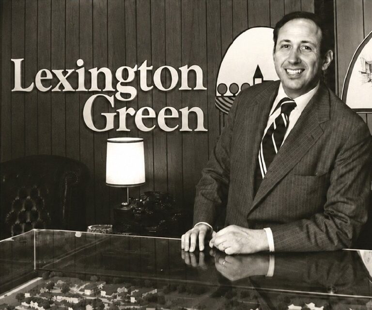 Archival photograph of founder Ron Benach beside a Lexington Green community model